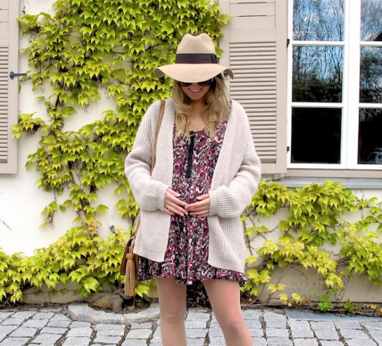 Beige Floral Dress. Fashion Blogger Girl by Style Blog Heartfelt Hunt. Girl with blond, loose curls wearing a beige cardigan, floral dress, floppy hat, tassel bag and beige boots.