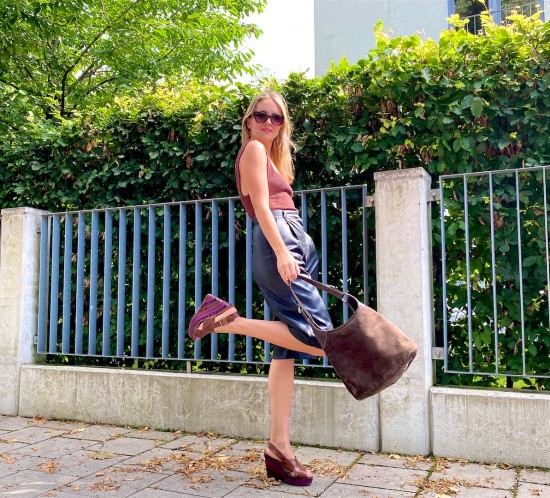Brown Faux Leather. Fashion Blogger Girl by Style Blog Heartfelt Hunt. Girl with blond hair wearing a brown structured top, faux leather shorts, edgy sunglasses, brown bag and brown heels.