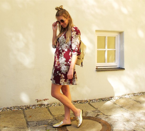 Burgundy Flower Dress. Fashion Blogger Girl by Style Blog Heartfelt Hunt. Girl with blond half-up half-down bun wearing a burgundy flower dress, round sunglasses, Michael Kors backpack and mules.