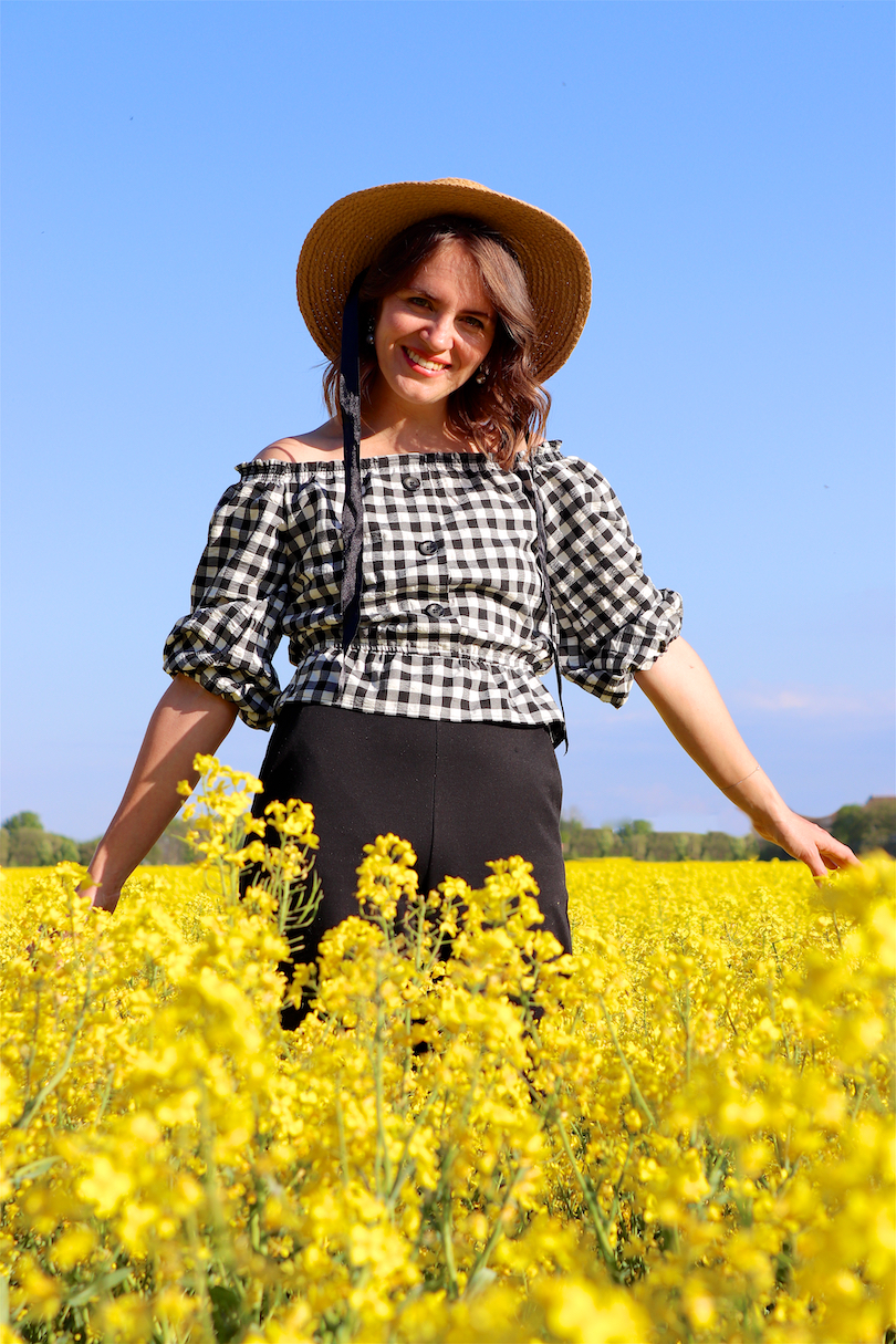 Canola Love. Fashion Blogger Girl by Style Blog Heartfelt Hunt. Girl with blond beach waves wearing an off-shoulder gingham blouse, black culotte, straw hat and straw bag.