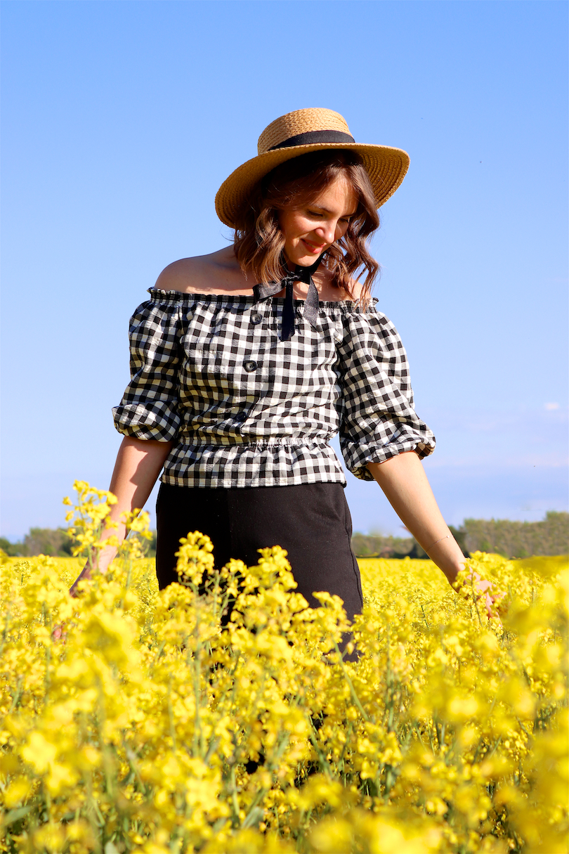 Canola Love. Fashion and Style Blog Girl from Heartfelt Hunt. Girl with blonde beach waves wearing an off-shoulder gingham blouse, black culotte, straw hat and straw bag.