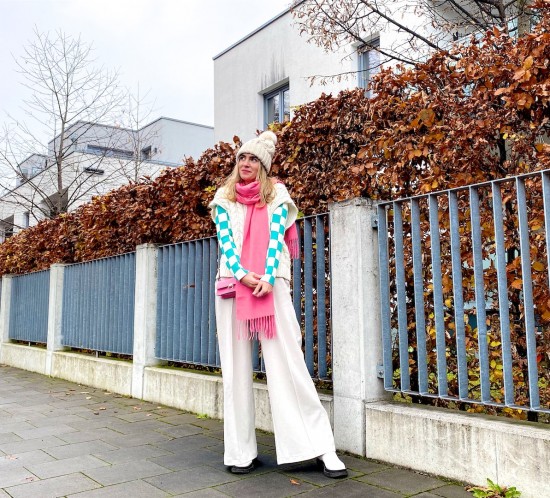 Checkboard Top. Fashion Blogger Girl by Style Blog Heartfelt Hunt. Girl with blond hair wearing a checkboard top, knit vest, pompom beanie, pink scarf, pink mini bag, wide leg pants and white boots.