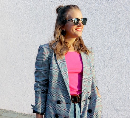 Checked Pink. Fashion Blogger Girl by Style Blog Heartfelt Hunt. Girl with blond hair and scrunchie wearing a checked blazer, pink top, mom jeans, green earrings, green sunglasses, transparent bag, belt and Timberland boots.