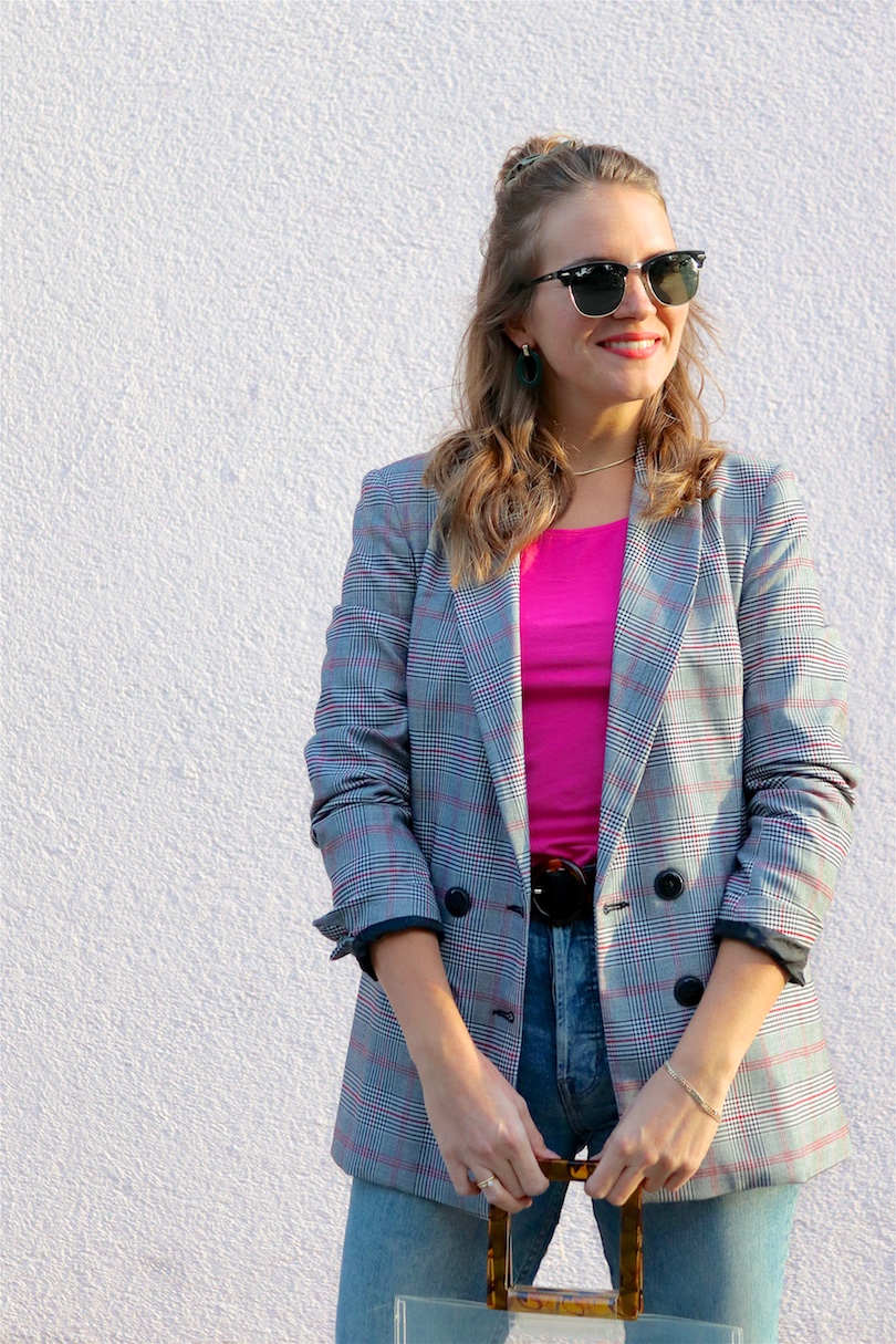 Checked Pink. Fashion Blogger Girl by Style Blog Heartfelt Hunt. Girl with blond hair and scrunchie wearing a checked blazer, pink top, mom jeans, green earrings, green sunglasses, transparent bag, belt and Timberland boots.