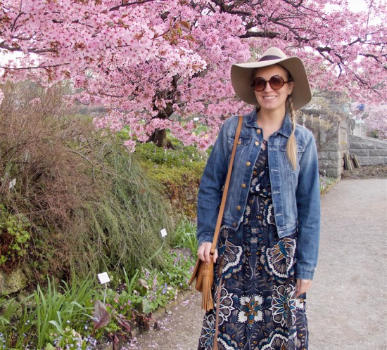 Cherry Blossom. Fashion Blogger Girl by Style Blog Heartfelt Hunt. Girl with blond dutch side braid wearing a flower dress, denim jacket, floppy hat, tassel bag and boots.