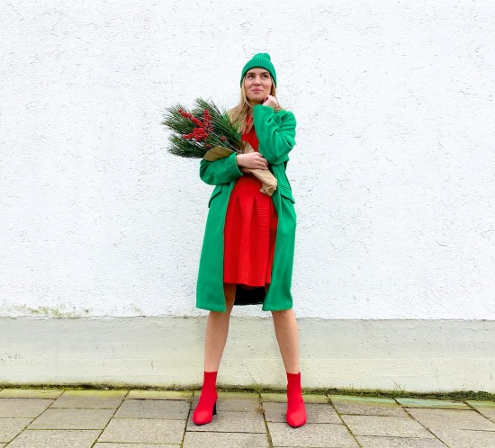 Classic Christmas Look. Fashion Blogger Girl by Style Blog Heartfelt Hunt. Girl with blond hair wearing a green coat, red dress, green beanie and red boots.