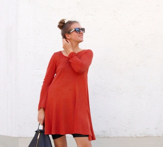 Cycling Shorts. Fashion Blogger Girl by Style Blog Heartfelt Hunt. Girl with blond, high messy bun wearing cycling shorts, orange dress, tortoiseshell sunglasses, Rebecca Minkoff backpack and white boots.