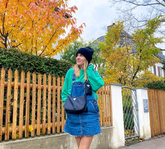 Denim Dungaree. Fashion Blogger Girl by Style Blog Heartfelt Hunt. Girl with blond hair wearing a denim dungaree, green sweatshirt, black 90s bag, green socks and chelsea boots.