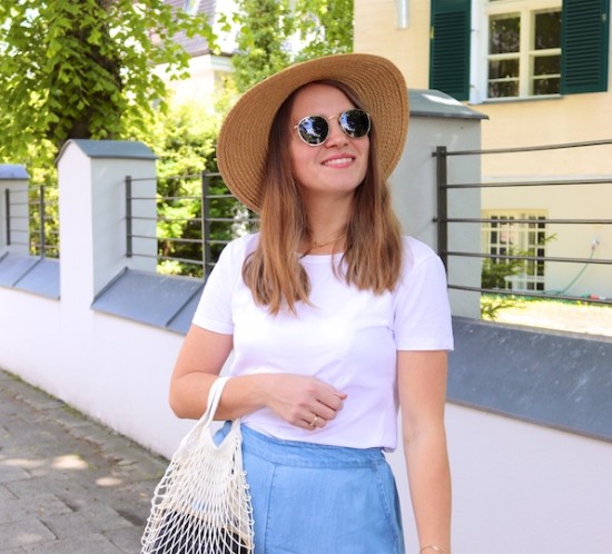 Denim Ruffles. Fashion Blogger Girl by Style Blog Heartfelt Hunt. Girl with blond hair wearing pants with denim ruffles, T-shirt, straw hat, Ray-Ban sunglasses, net bag and straw flats.