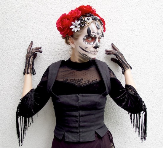 Dia De Los Muertos 2018. Fashion Blogger Girl by Style Blog Heartfelt Hunt. Girl with blond hair and flower crown showing her Halloween costume wearing a dress with fringes, embroidered skirt, bodice and flower necklace.