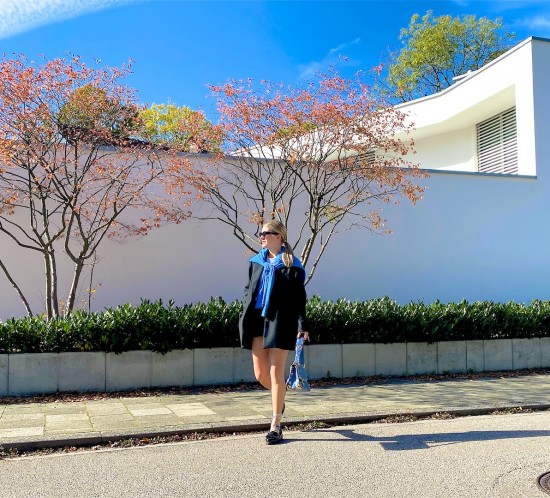 Fall Blues. Fashion Blogger Girl by Style Blog Heartfelt Hunt. Girl with blond sleek ponytail wearing a blue sweater, oversized blazer, slim sunglasses, faux leather shorts, blue Louis Vuitton bag, floral socks and chunky loafers.