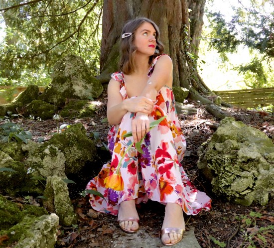 Flower Dress. Fashion Blogger Girl by Style Blog Heartfelt Hunt. Girl with blond loose waves and rhinestone hair clip wearing a flower dress, rhinestone earrings, metallic clutch, metallic heels.
