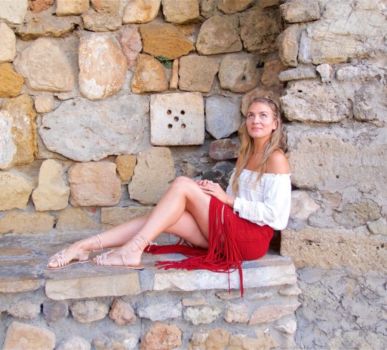 Fringe Skirt. Fashion Blogger Girl by Style Blog Heartfelt Hunt. Girl with blond half-up half-down knot wearing a red fringe skirt, white off-shoulder top, vintage Chanel bag and lace up sandals.