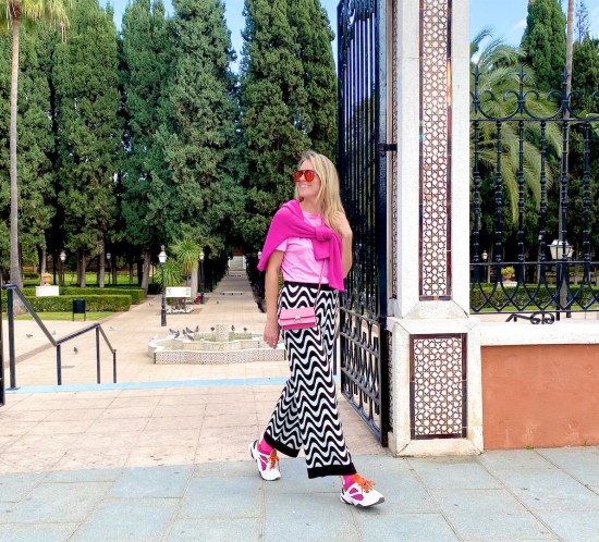 Funky Pants. Fashion Blogger Girl by Style Blog Heartfelt Hunt. Girl with blond hair wearing funky pants, pink sweater, pink T-shirt, orange sunglasses, pink mini bag, pink socks and chunky sneakers.