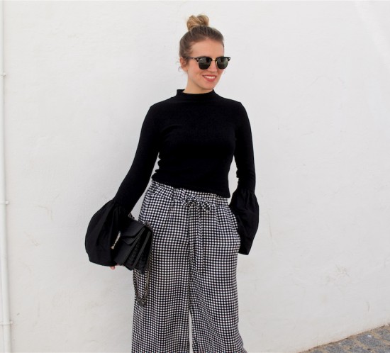 Gingham Culottes. Fashion Blogger Girl by Style Blog Heartfelt Hunt. Girl with blond high bun wearing gingham culottes, top with trumpet sleeves, Ray-Ban sunglasses, bag and lace up ballet flats.