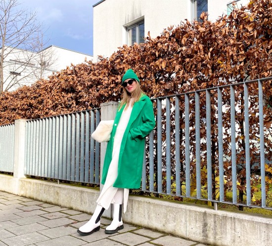 Green Coat. Fashion Blogger Girl by Style Blog Heartfelt Hunt. Girl with blond hair wearing a green coat, white knit dress, green beanie, faux fur bag and chunky white boots.
