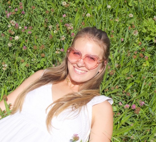 Heart Shaped Sunnies. Fashion Blogger Girl by Style Blog Heartfelt Hunt. Girl with blond half-up half-down hairstyle with a dutch braid wearing heart shaped sunnies, a white summer dress and straw bag.