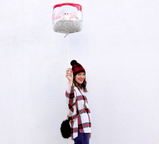 Holiday Season Gear. Fashion Blogger Girl by Style Blog Heartfelt Hunt. Girl with blond, loose curls wearing a plaid beanie, plaid sweater, wide leg jeans, faux fur bag and glossy boots.