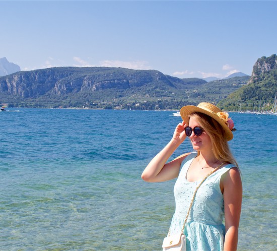 Italian Road Trip. Fashion Blogger Girl by Style Blog Heartfelt Hunt. Girl with long, blond hair wearing a lace dress, straw hat, vintage Chanel bag, sandals and sunglasses.