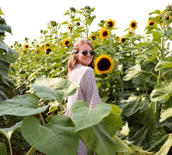 Late Summer Vibes. Fashion Blogger Girl by Style Blog Heartfelt Hunt. Girl with blond loose waves and tortoiseshell hair clips wearing a checked dress, Ray-Ban sunglasses, straw bag and chunky sneakers.