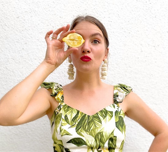 Lemon Print. Fashion Blogger Girl by Style Blog Heartfelt Hunt. Girl with blond, low bun wearing a lemon print top, tassel earrings, straw belt and beige pants.