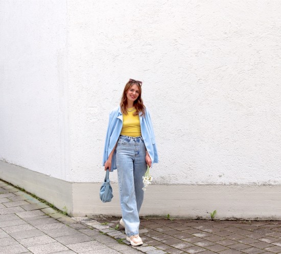 Light Blue Blazer. Fashion Blogger Girl by Style Blog Heartfelt Hunt. Girl with blond hair wearing a light blue blazer, yellow top, wide leg jeans, white bag and chunky sneakers.
