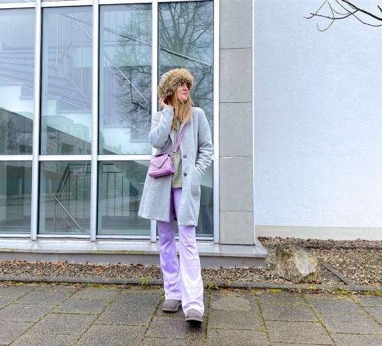 Pastel Lilac. Fashion Blogger Girl by Style Blog Heartfelt Hunt. Girl with blond hair wearing pastel lilac pants, gray coat, faux fur hat, mint sweater, lilac bag and gray Ugg boots.
