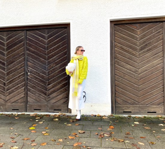 Oversized Scarf. Fashion Blogger Girl by Style Blog Heartfelt Hunt. Girl with blond sleek bun wearing an oversized scarf, yellow sweater, white knit dress, faux fur bag and white boots.