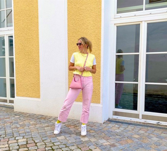 Pink Denim. Fashion Blogger Girl by Style Blog Heartfelt Hunt. Girl with blond hair and pink hair claw clip wearing pink denim, knitted vest, pink Staud bag, yellow socks and Nike sneakers.