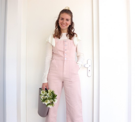Pink Jumpsuit. Fashion Blogger Girl by Style Blog Heartfelt Hunt. Girl with blond half-up half-down loose waves and scrunchie wearing a pink jumpsuit, blouse with ruffles, Louis Vuitton bucket bag and lace-up heels.