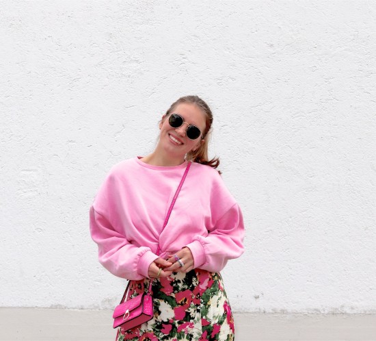 Pink Roses. Fashion Blogger Girl by Style Blog Heartfelt Hunt. Girl with blond ponytail and pink scrunchie wearing a pink roses dress, pink sweatshirt, Ray-Ban sunglasses, pink mini bag, green socks and white Converse sneakers.