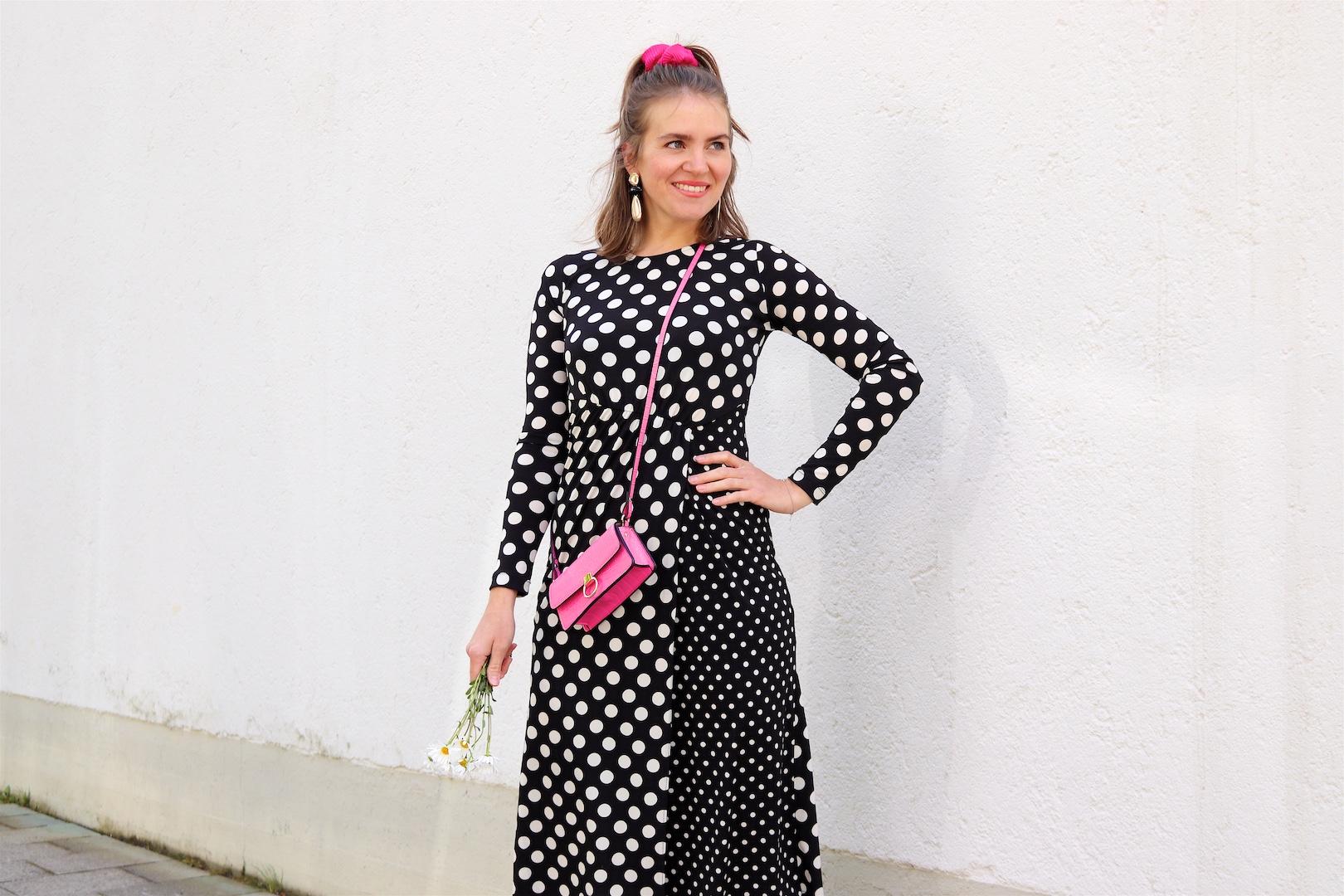 Polka Dots Marguerites. Fashion and Style Blog Girl from Heartfelt Hunt. Girl with blonde half-up half-down hairstyle and pink scrunchie wearing a polka dot dress, gold earrings, pink mini bag and pointed flats.