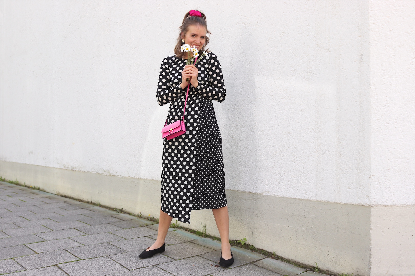 Polka Dots Marguerites. Fashion and Style Blog Girl from Heartfelt Hunt. Girl with blonde half-up half-down hairstyle and pink scrunchie wearing a polka dot dress, gold earrings, pink mini bag and pointed flats.