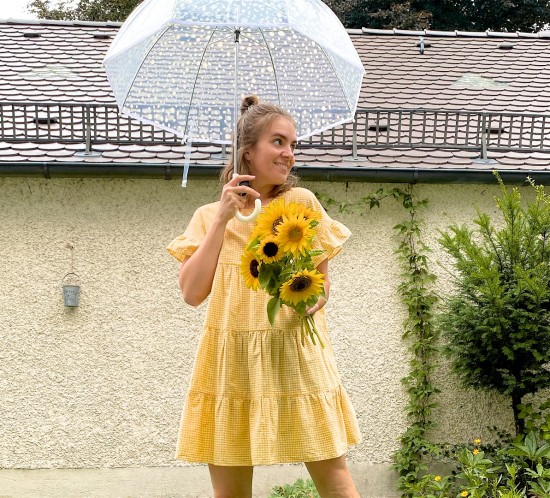 Rainy Summer Day. Fashion Blogger Girl by Style Blog Heartfelt Hunt. Girl with blond half-up half-down messy bun wearing a gingham dress and white Nike sneakers.