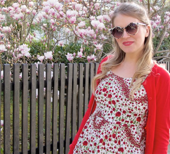 Red & Blush. Fashion Blogger Girl by Style Blog Heartfelt Hunt. Girl with blond half-up half-down bun wearing a red cardigan, floral dress, blush bag, scarf and velvet loafers.