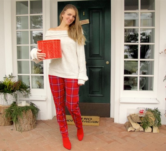 Red Tartan Pants. Fashion Blogger Girl by Style Blog Heartfelt Hunt. Girl with blond hair and a box for Christmas cookies wearing red tartan pants, off shoulder sweater and red sock boots.