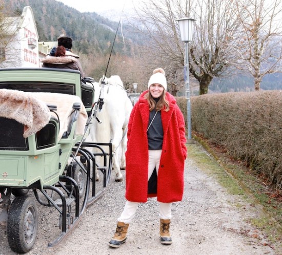 Sleigh Ride. Fashion Blogger Girl by Style Blog Heartfelt Hunt. Girl with blond hair wearing a red teddy coat, corduroy pants, turtleneck sweater, pompom beanie and Sorel boots.