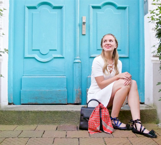 White Lace Up Dress. Fashion Blogger Girl by Style Blog Heartfelt Hunt. Girl with blond braided half-up half-down hairstyle wearing a white lace up dress, red vintage scarf, vintage MCM bag and lace up ballet flats.