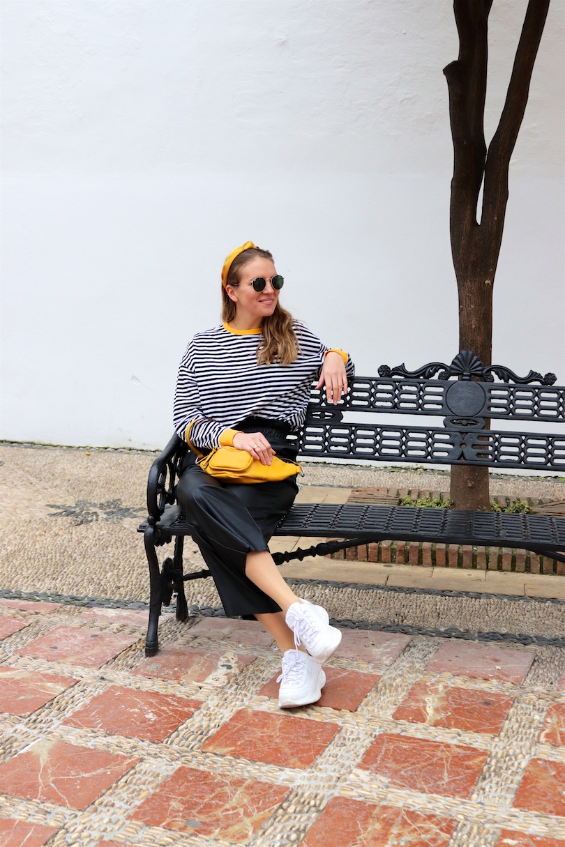 Yellow Belt Bag. Fashion and Style Blog Girl from Heartfelt Hunt. Girl with blonde hair and yellow headband wearing a yellow belt bag, striped top, faux leather culotte, Ray-Ban sunglasses and chunky sneakers.