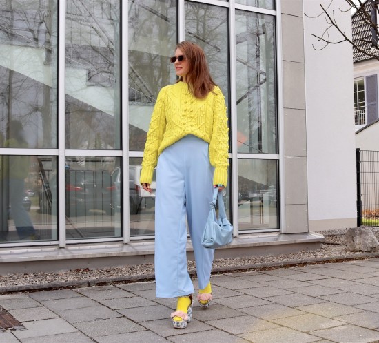 Yellow Blue. Fashion Blogger Girl by Style Blog Heartfelt Hunt. Girl with blond hair wearing a yellow & blue outfit with a yellow sweater, blue pants, yellow socks, blue knotted bag and blue heels.