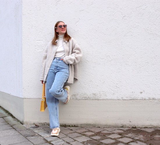 Yellow Spring Vibes. Fashion Blogger Girl by Style Blog Heartfelt Hunt. Girl with blond hair wearing a yellow bag, shacket, turtleneck sweater, wide leg jeans, yellow 90s bag and chunky sneakers.